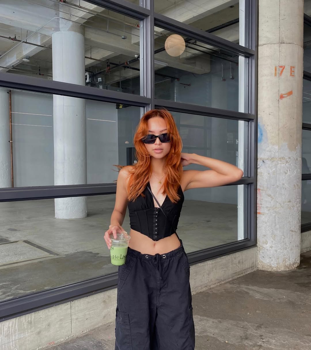 Copper Hair Summer Ideas 2026: Casual Chic Look Woman with vibrant copper hair smiling, wearing a light blue denim jacket over a white top, perfect for copper hair summer ideas 2026. Her hair is styled in loose waves, complementing a casual daytime look.
