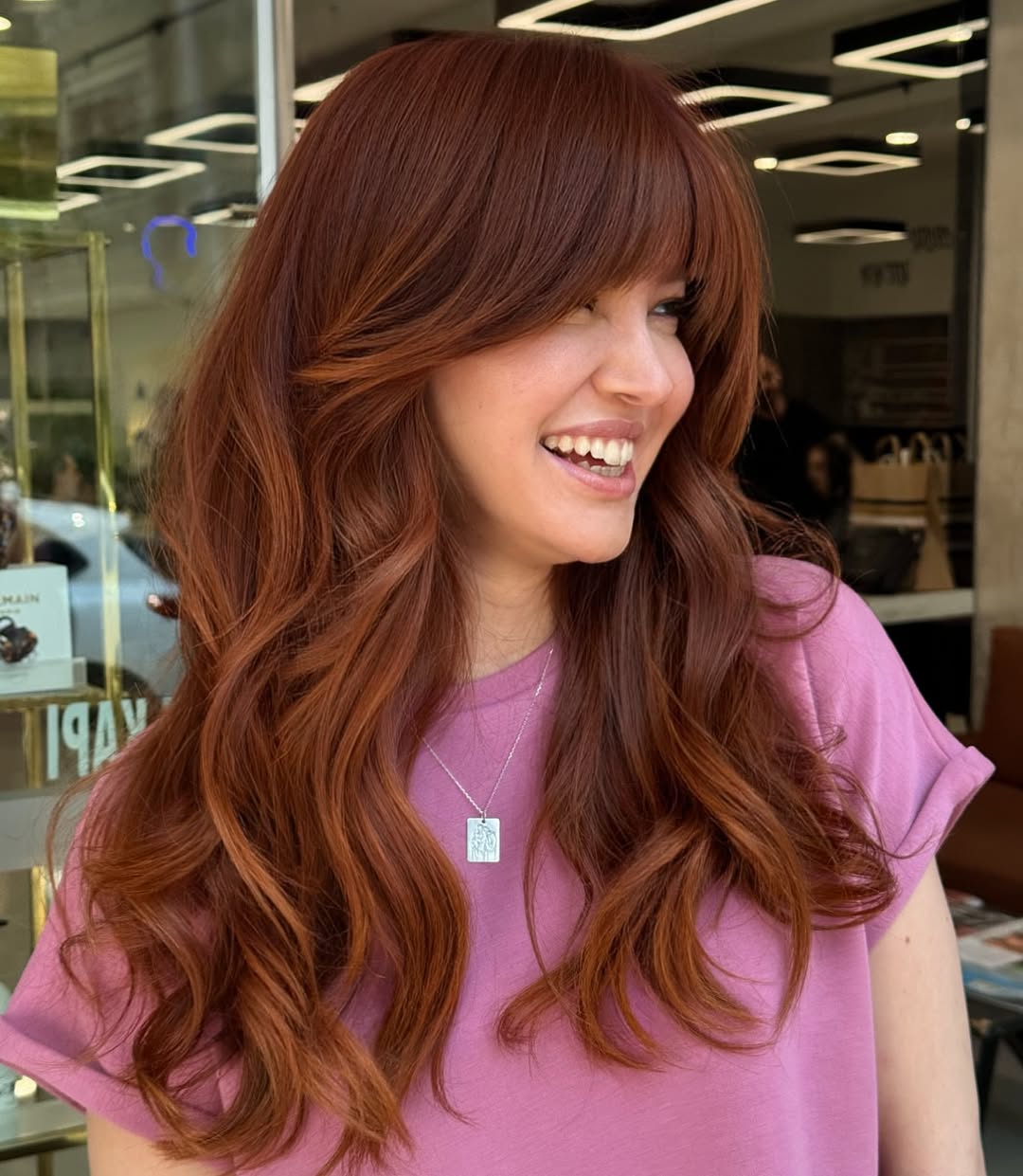 Stunning Copper Hair Summer Ideas 2026: Flowy White Sundress Woman with long, wavy, bright copper hair styled for summer, wearing a flowy white sundress with delicate straps. She carries a straw bag, accessorized with gold jewelry, perfect for a sunny outdoor event.