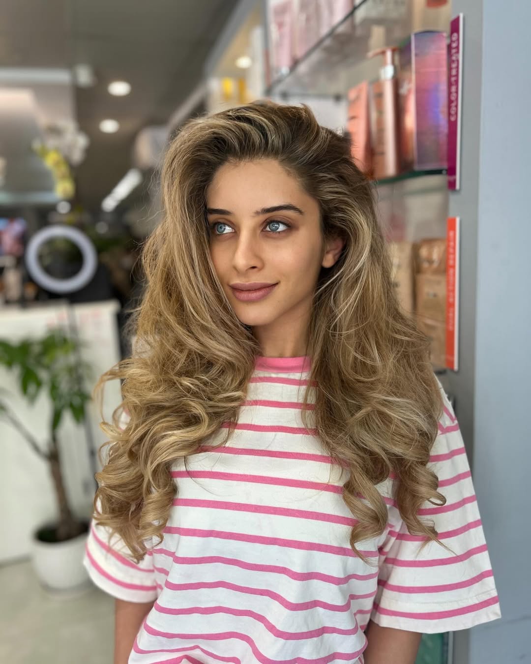 Chic Ponytail for Long Hair Summer Hairstyles 2026 Woman with long, wavy blonde hair styled in a chic ponytail, perfect for long hair summer hairstyles 2026. She wears a flowy white sundress, ideal for a beach or casual outdoor event.