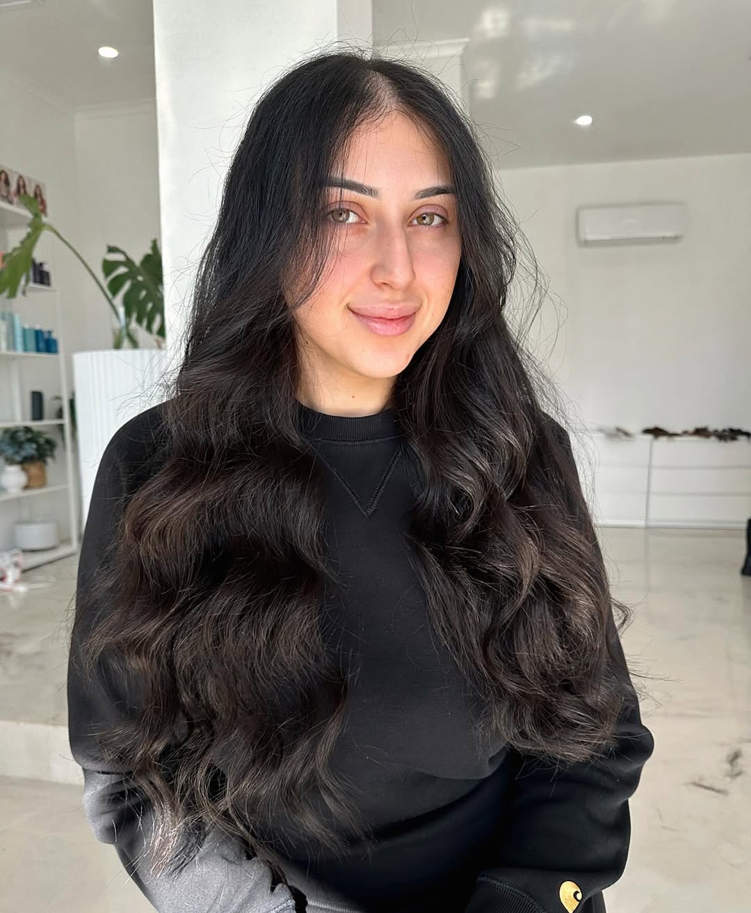Chic Long Hair Summer Hairstyles 2026: Effortless Updo Woman with sleek, pulled-back long hair summer hairstyles 2026, accessorized with a white scrunchie and delicate gold earrings, enjoying a sunny outdoor setting.