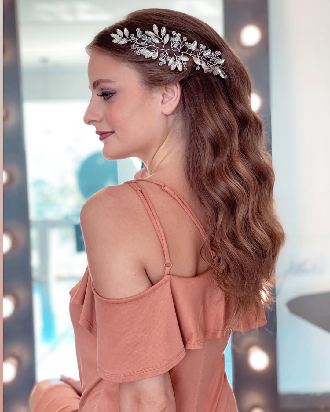 Effortless Wavy Look: Simple Summer Hairstyles 2026 Close-up of a woman with long, sun-kissed brown hair styled in simple summer waves, perfect for 2026. Her hair has subtle highlights, framing her face softly for a relaxed look.