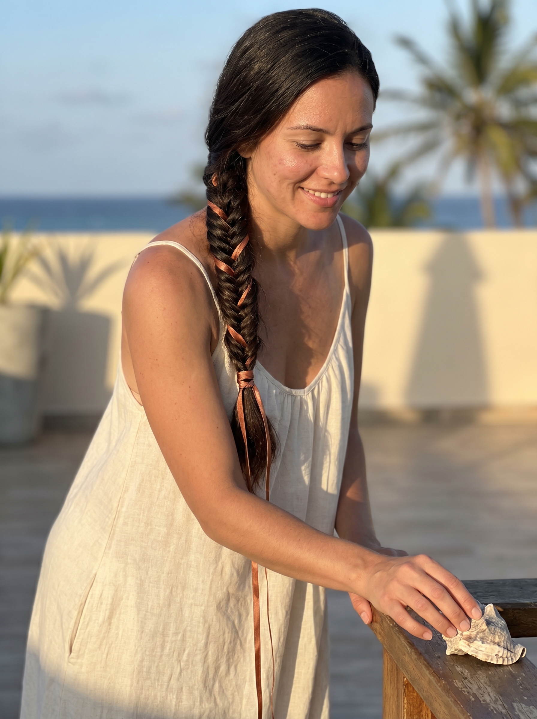 Romantic fishtail braid with copper-penny ribbons for summer 2026. This whimsical style features mushroom brown lowlights, perfect for a date night or wedding guest.