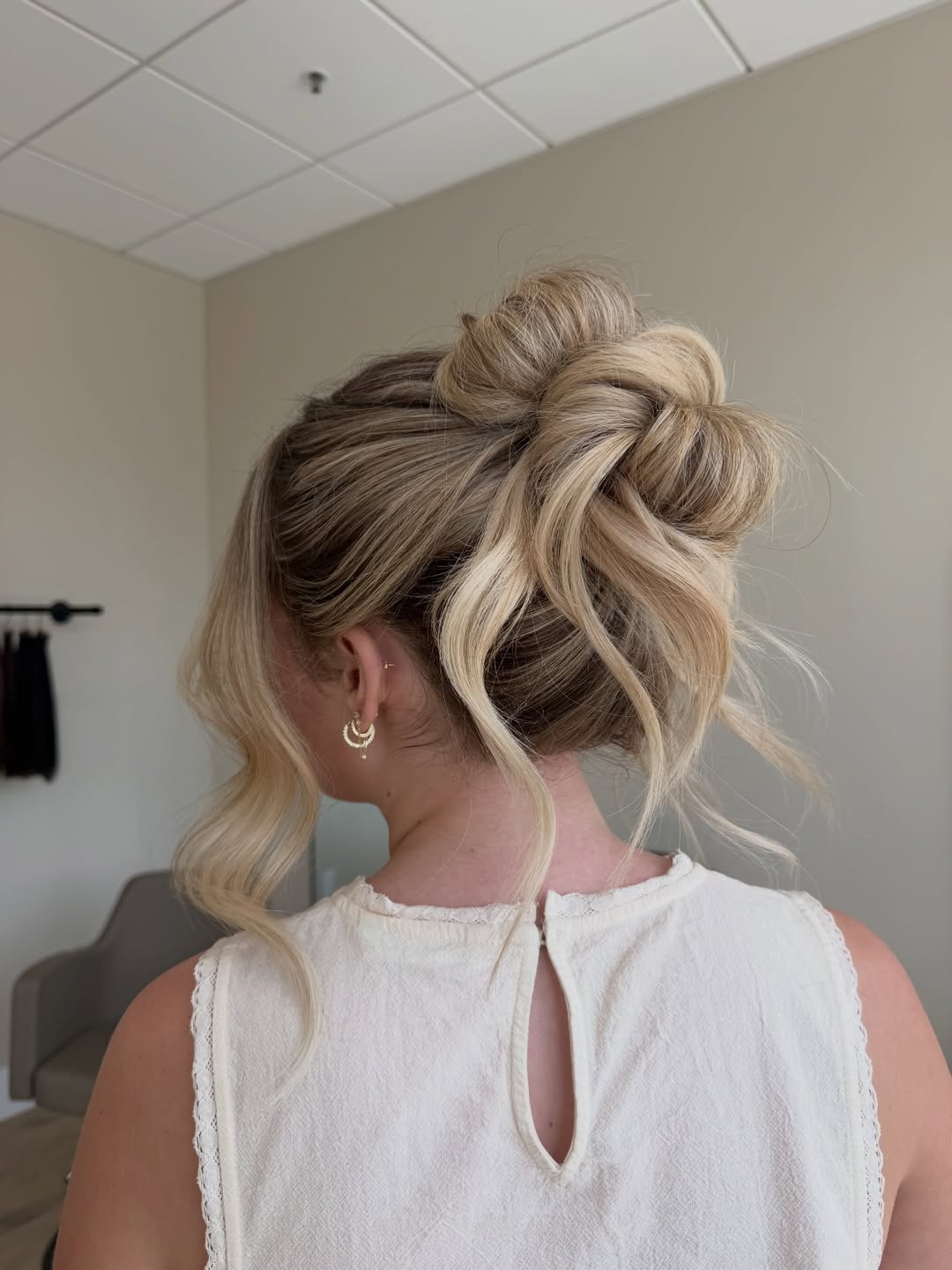 Beautiful bride with a soft, romantic updo featuring delicate braids and loose tendrils, perfect for summer bride hairstyles 2026. This elegant look complements a strapless wedding gown for an outdoor ceremony.