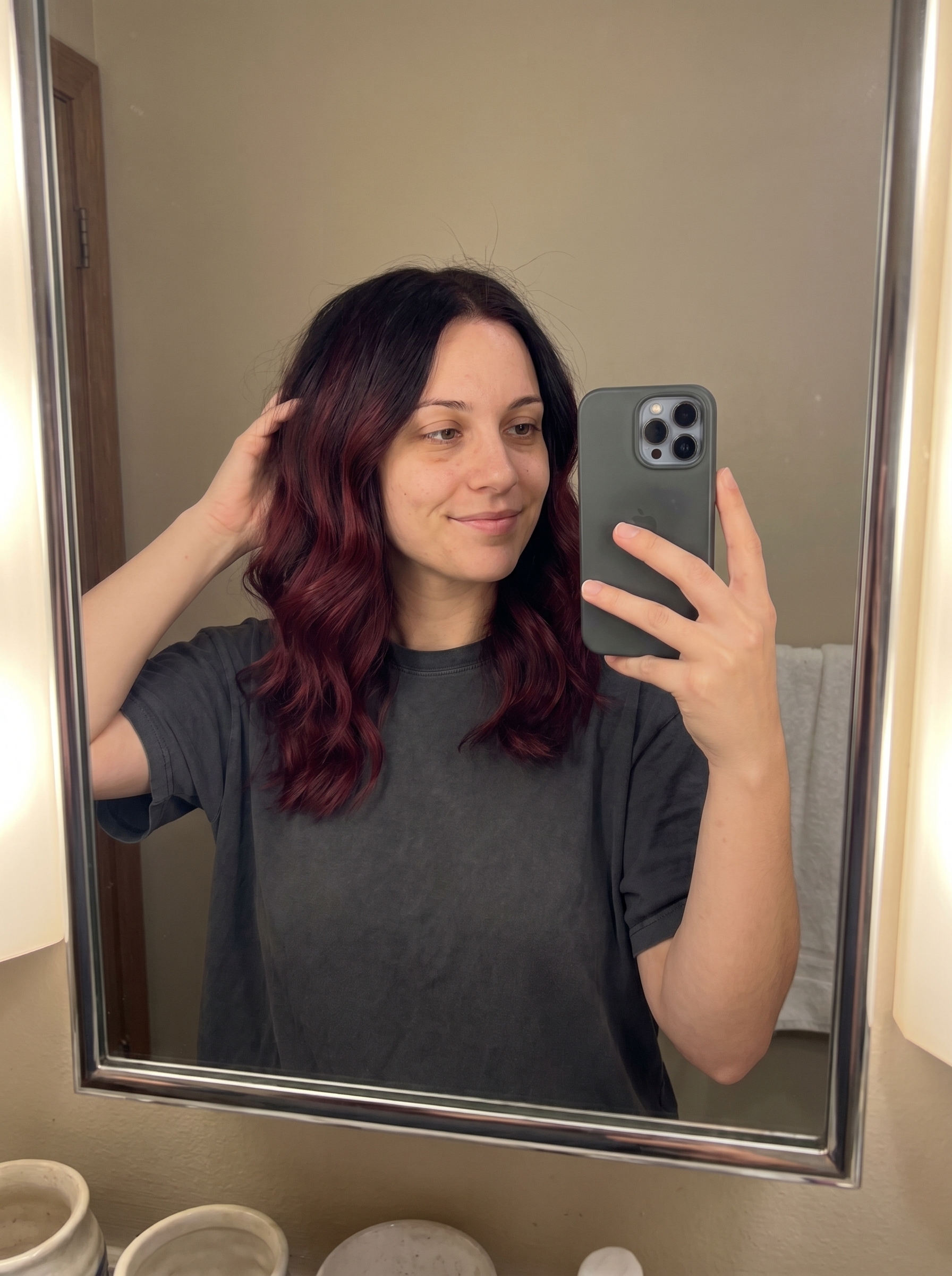 Hair dyed in a 'Cherry Cola Melt' gradient, featuring bold black cherry, burgundy, and deep plum hues, an edgy option for summer dark hair looks 2026. The vibrant red-purple shade is striking for any occasion.
