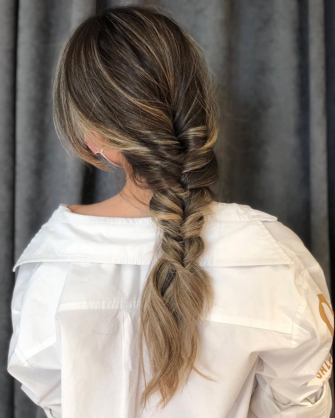 Chic Braided Updo: Summer Hairstyle Ideas 2026 Close-up of a woman with long, sun-kissed hair in a relaxed braided updo, showcasing summer hairstyle ideas 2026 for casual everyday wear.