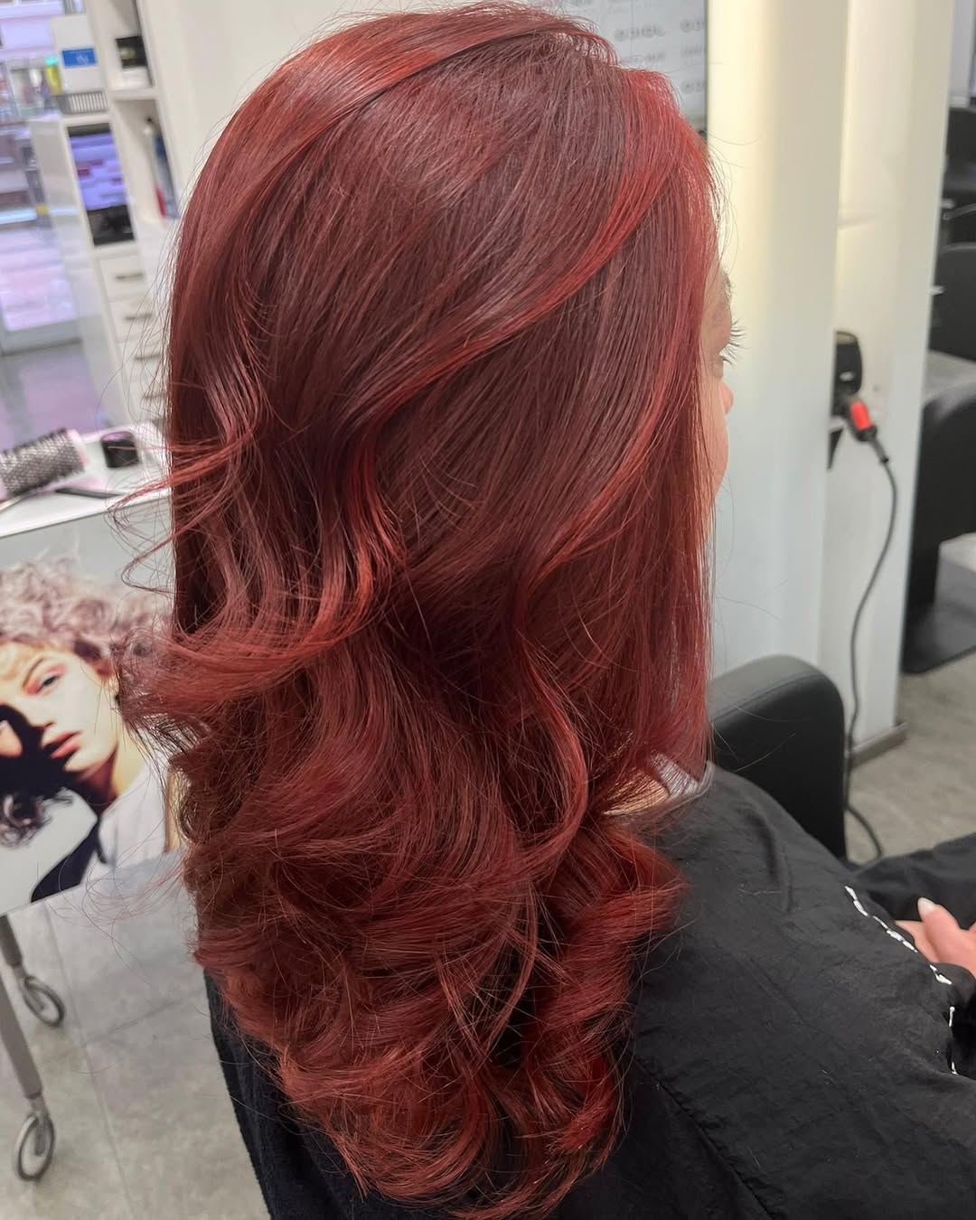 Stunning Summer Red Hair Looks 2026: Effortless Waves A beautiful woman with vibrant summer red hair looks 2026, styled in loose waves, wearing a white off-the-shoulder top and delicate gold jewelry, perfect for a sunny day.
