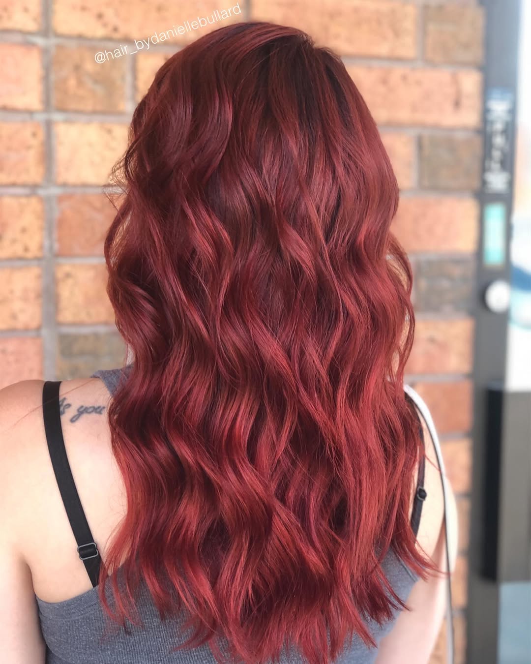 Stunning Summer Red Hair Looks 2026: Floral Dress Vibes A woman with vibrant ginger red hair smiles, styled in loose waves, wearing a floral sundress, perfect for summer red hair looks 2026.
