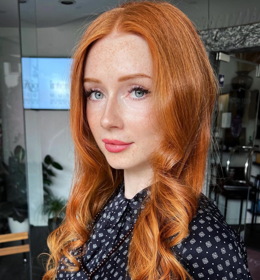 Stunning Summer Red Hair Looks 2026: Wavy & Fresh Close-up of a woman with vibrant red hair styled in soft waves, wearing subtle makeup, showcasing summer red hair looks 2026 for a casual day.