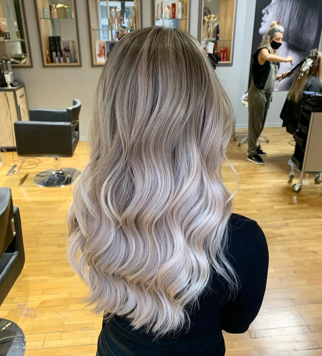 Close-up of a woman with a natural, sun-kissed 'summer soft hair color 2026' featuring subtle golden blonde highlights and soft waves, perfect for a warm weather look.