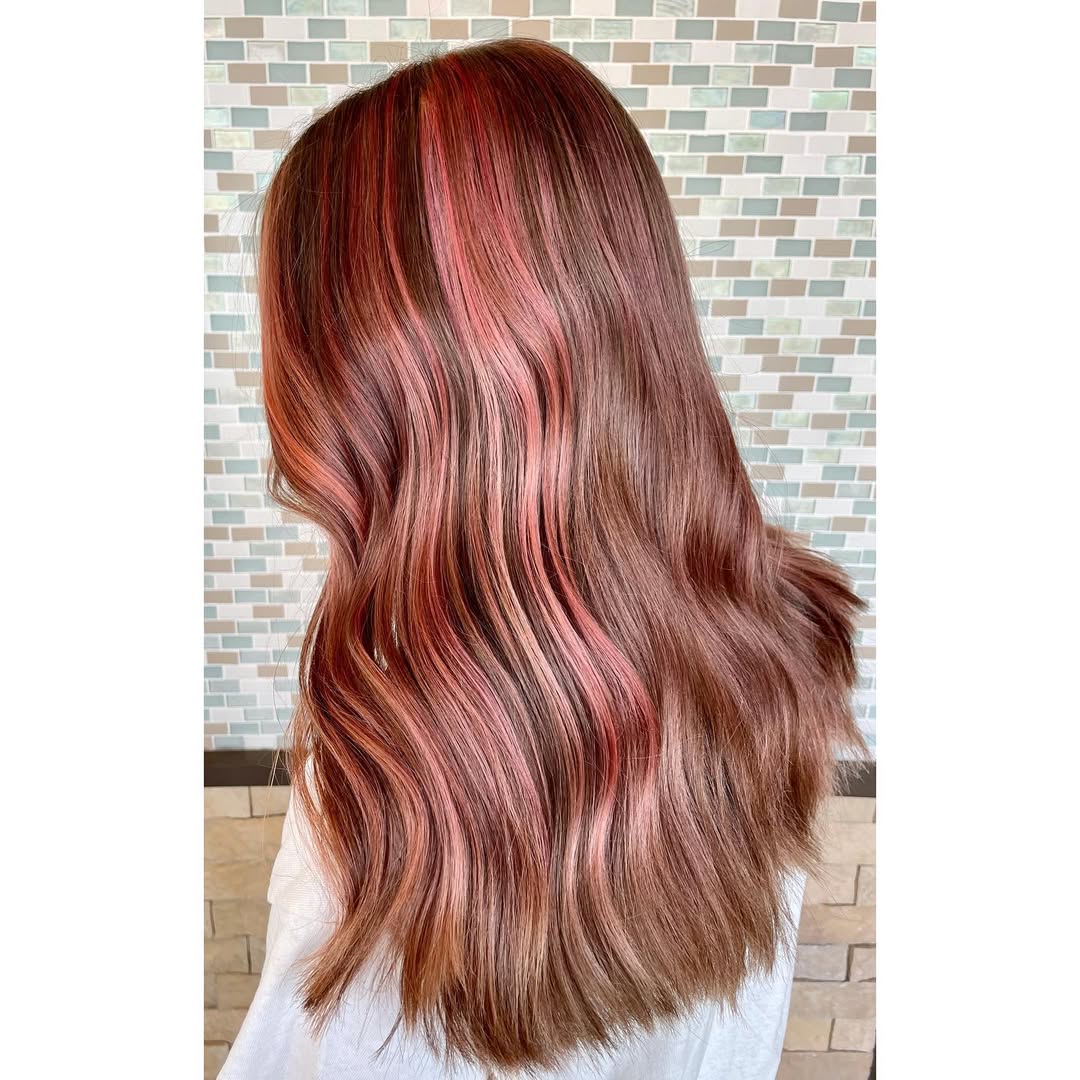 Woman with long, flowing waves showcasing a sun-kissed blonde summer soft hair color 2026, paired with a white flowy top, perfect for a casual beach day or outdoor brunch.