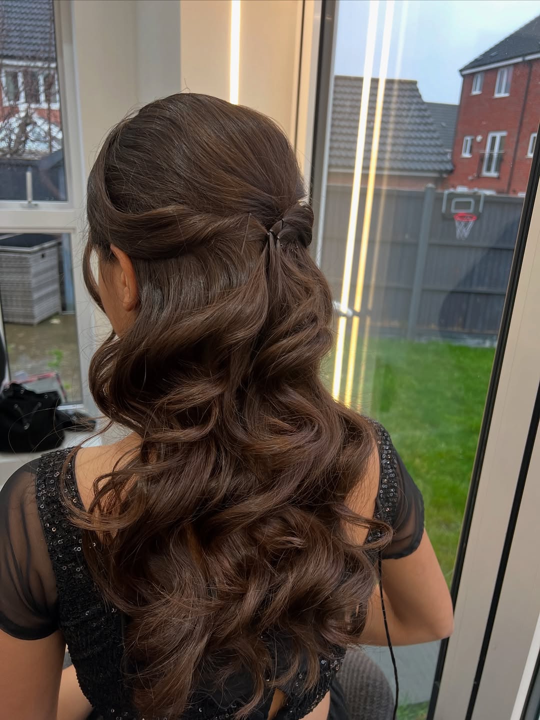 Elegant chignon bun with delicate floral pins, perfect summer wedding guest hairstyle 2026. Updo for formal event.