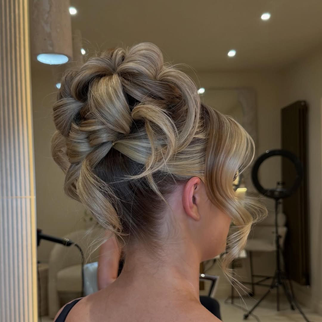 Beautiful blonde woman with a romantic, loosely braided updo, adorned with delicate white baby’s breath flowers, ideal for summer wedding hairstyle ideas 2026. Perfect for a garden or outdoor ceremony.