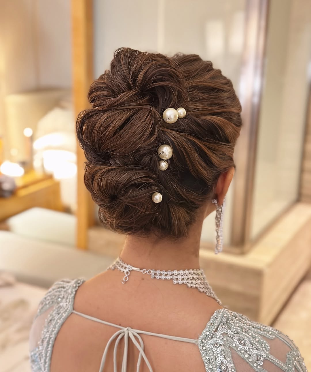 Beautiful blonde bride with a delicate floral headband, showcasing elegant summer wedding hairstyle ideas 2026. Her hair is styled in soft, romantic waves, perfect for an outdoor ceremony.