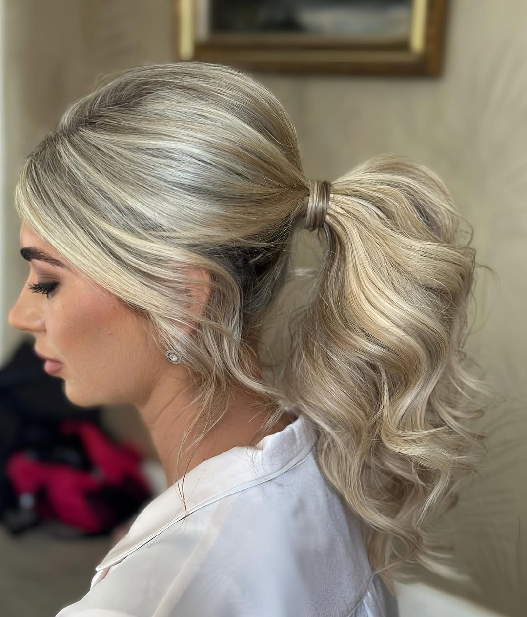 Elegant brunette bride with a soft half-up, half-down summer wedding hairstyle. Wavy hair cascades down with delicate braids and small white floral accents, perfect for a romantic outdoor ceremony in 2026.