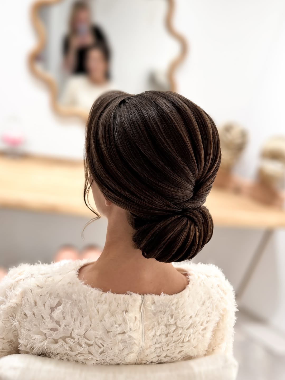 Beautiful bride with a cascading floral half-updo, showcasing elegant summer wedding hairstyle ideas 2026. Her brunette hair is styled with delicate braids and white flowers, perfect for an outdoor ceremony.