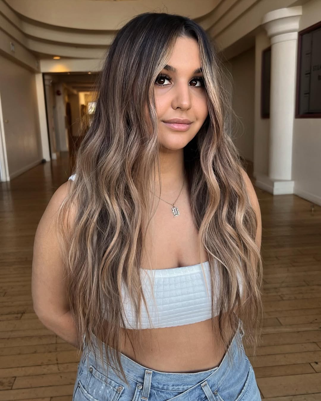 Effortless Beach Waves Hair for Summer 2026 Close-up of a woman with natural, sun-kissed beach waves hair featuring subtle highlights, perfect for summer 2026. Her hair frames her face beautifully, complementing a casual outdoor look.