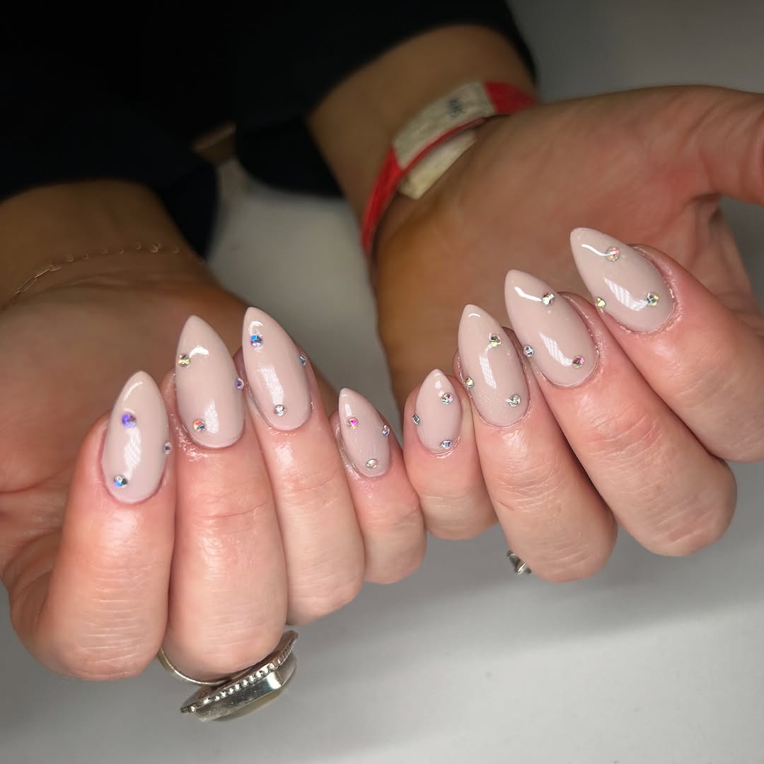 Glossy Nude Almond Nails Scattered With Iridescent Rhinestones