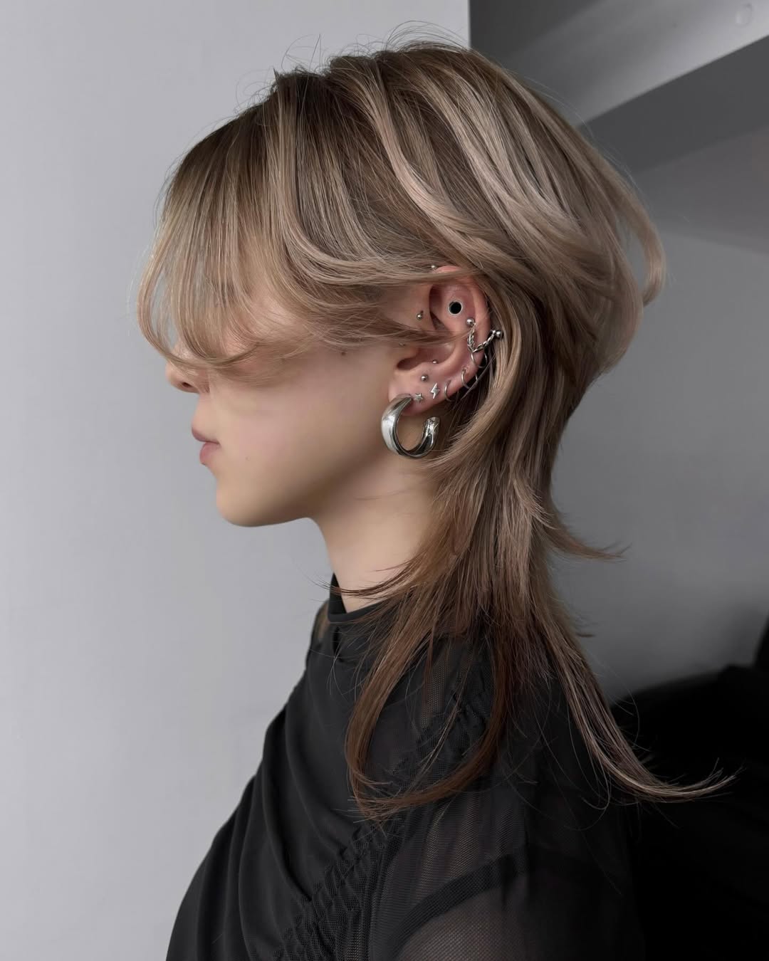 Chic Half-Up Hairstyle for Summer Medium Hair 2026 Woman with a chic, effortless half-up hairstyle perfect for hairstyles summer medium hair. Her blonde hair is gently pulled back, showing face-framing layers ideal for warm weather occasions.