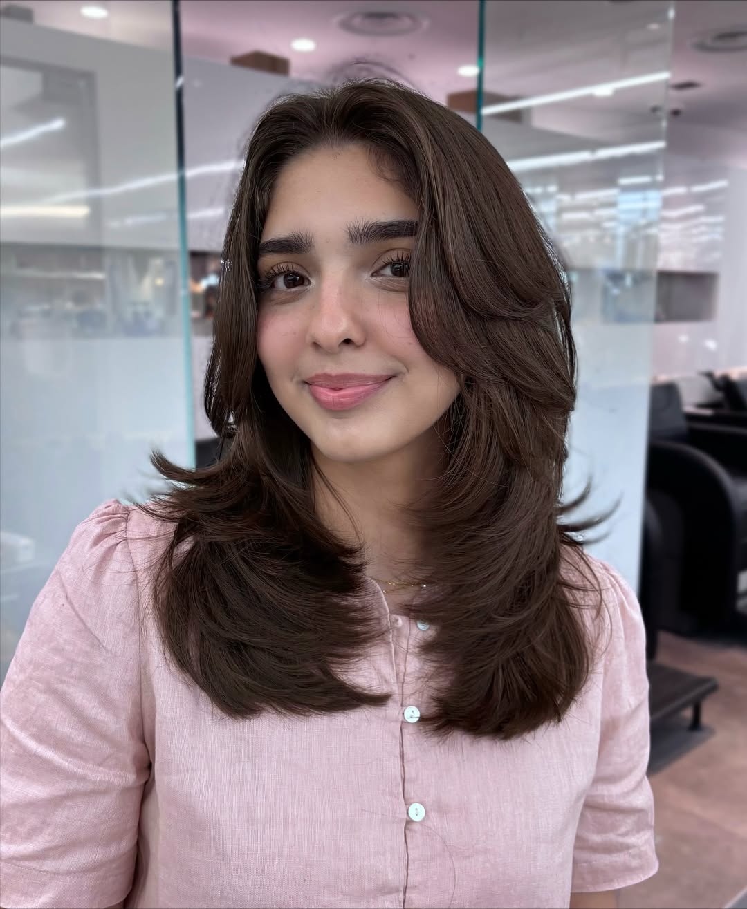 Effortless Messy Bun: Hairstyles Summer Medium Hair 2026 Woman with a chic, messy bun, ideal for hairstyles summer medium hair. This casual updo features subtle face-framing layers, perfect for warm weather.