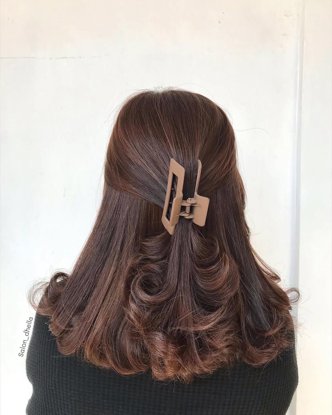 Chic Messy Bun: Hairstyles Summer Medium Hair 2026 Woman with a chic, messy bun updo, perfect for hairstyles summer medium hair. Her blonde hair is casually swept up, revealing face-framing layers.