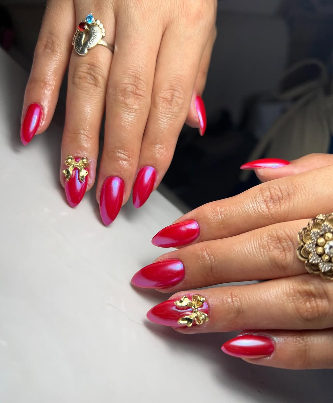 Shimmering Cherry Red Almond Nails With Gold Bows