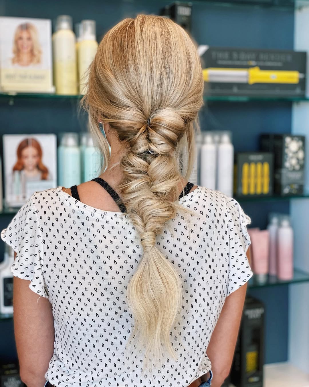 Close-up of a woman with long, dark, intricately braided hair, showcasing a beautiful summer braid hairstyle 2026. Perfect for warm weather.