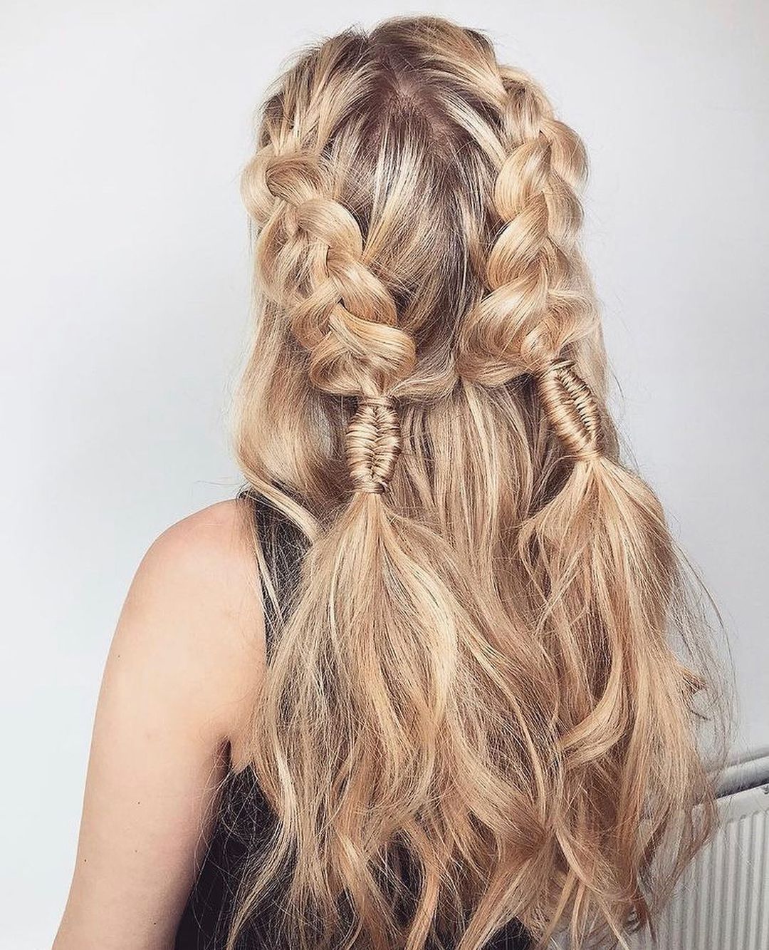 Close-up of a woman with long, sun-kissed brown hair styled in a chic, voluminous side braid, perfect for summer braid hairstyles 2026. Her hair has subtle blonde highlights, accentuating the intricate braid cascading over her shoulder, ideal for a casual day out.