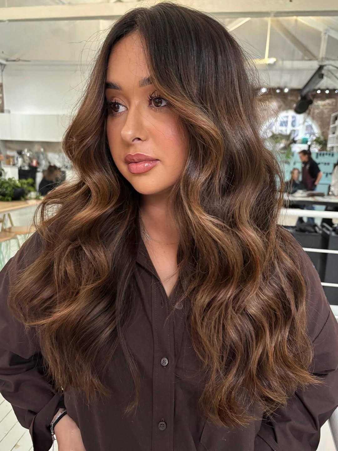 A woman with a chic low ponytail, braided into a fishtail, showcasing summer cool hair ideas 2026. This elegant style is perfect for a breezy outdoor event.