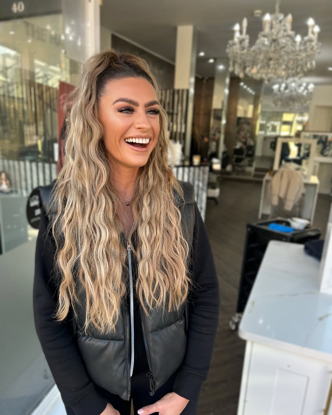 A woman with vibrant pink and purple ombre hair styled in loose waves, perfect for summer cool hair ideas 2026. Her hair shines under natural light, showcasing the dual-tone color trend.