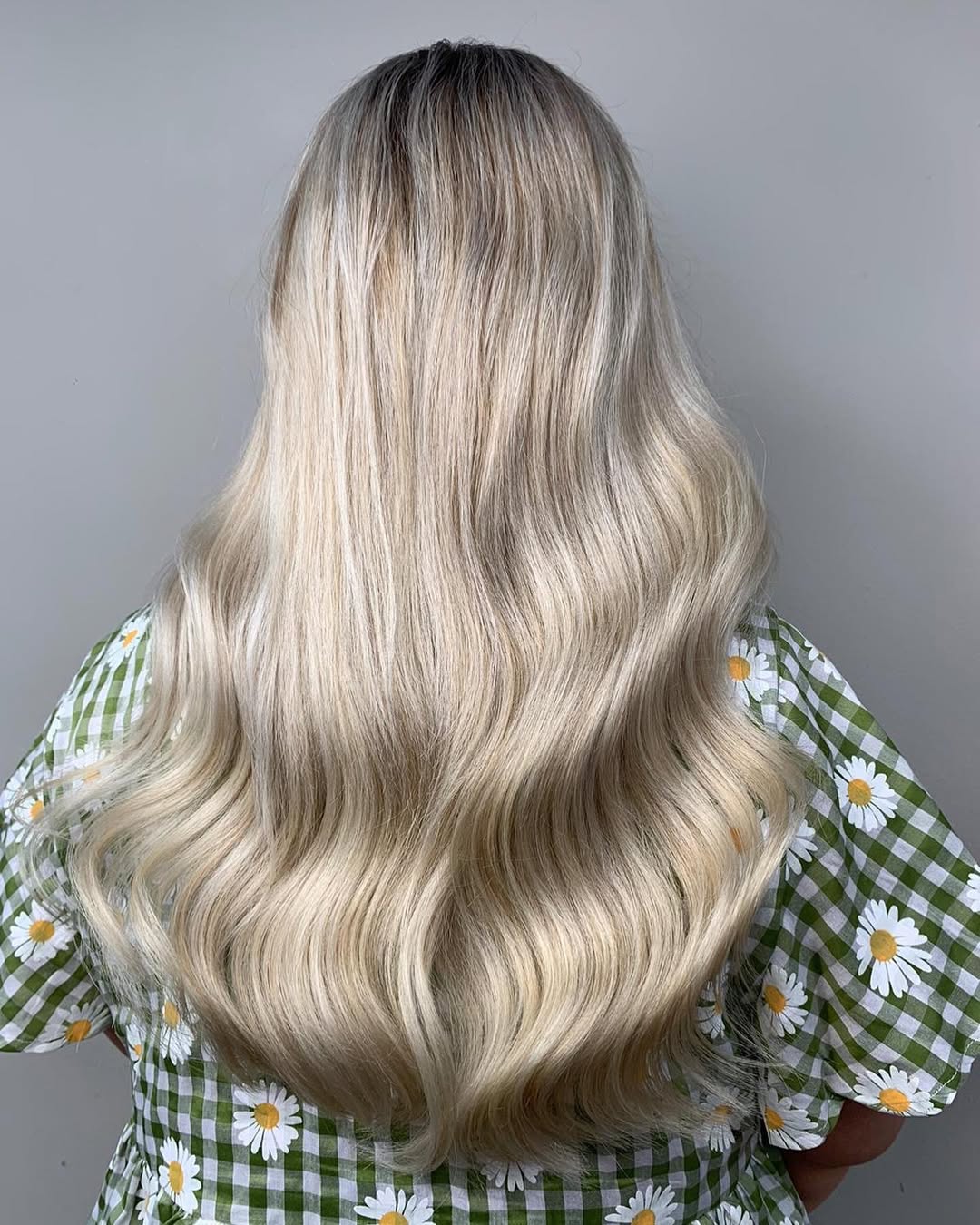 A young woman smiling, showcasing summer cute hair ideas 2026 with loose, beachy waves and subtle braids framing her face, perfect for a casual sunny day.