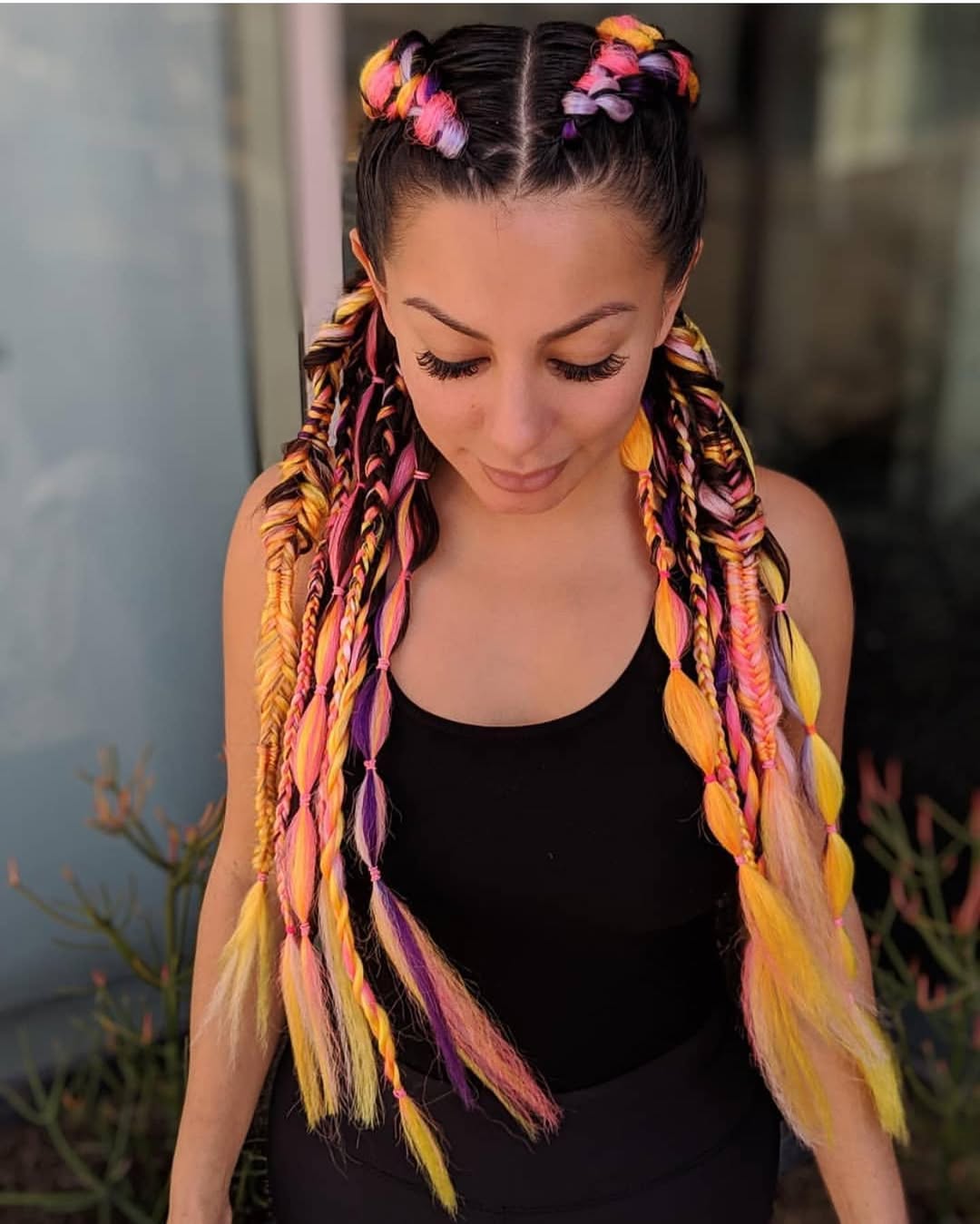 A young woman with adorable summer cute hair ideas 2026, featuring braided pigtails intertwined with a colorful scarf, perfect for a casual sunny day look.