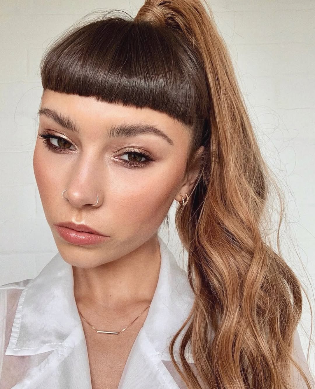 Model with long, loose waves and a braided half-updo, showcasing a cute summer hair idea for 2026. Perfect for casual daywear.