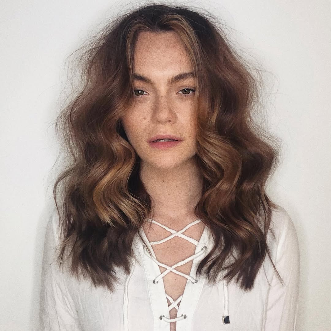 Close-up of a young woman with a trendy half-up braided style, perfect for summer cute hair ideas 2026. Her blonde hair is intricately woven, showcasing a fresh and elegant look for warm weather.