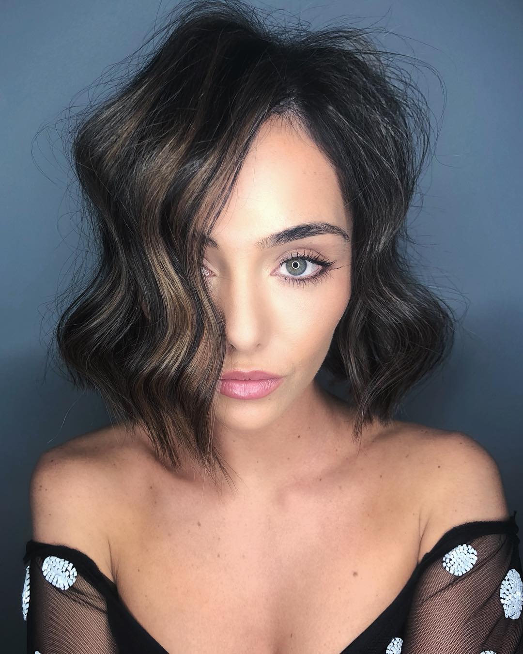 Close-up of a woman with long, sun-kissed hair styled in soft waves with delicate braids, showcasing summer cute hair ideas 2026 for a romantic look.