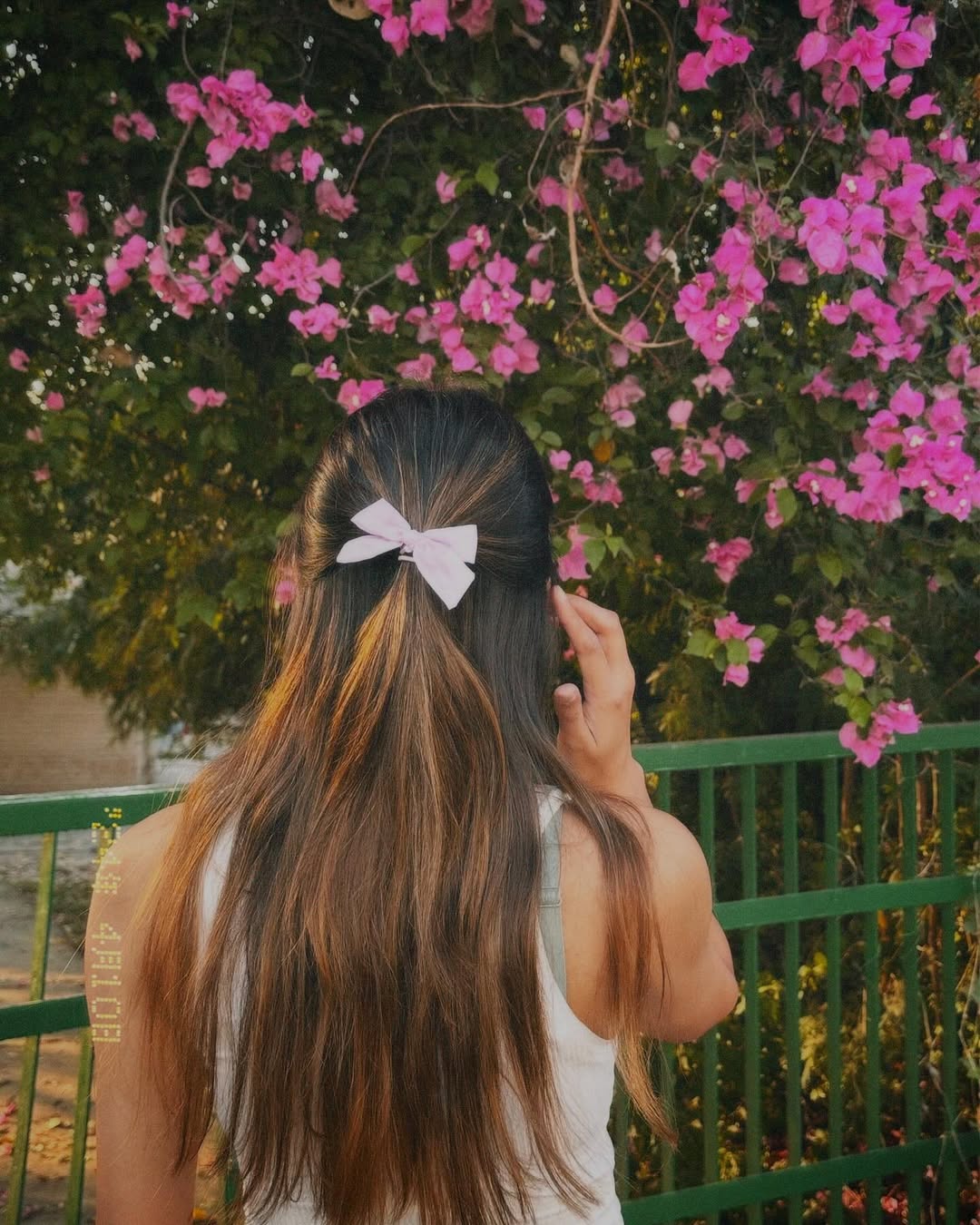 Blonde woman with a boho-chic messy bun, perfect for summer cute hair ideas. Her hair is casually styled with loose strands framing her face, ideal for an outdoor or festival look.