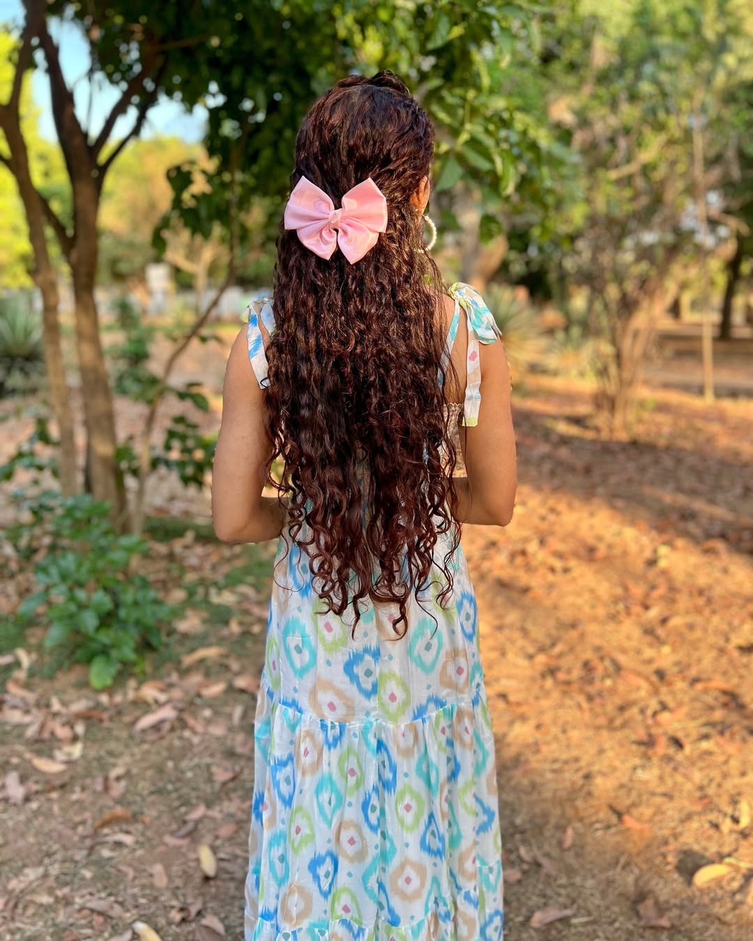 Close-up of a woman with defined, bouncy auburn curly hair styled with the focus keyword: summer hair curly ideas 2026. Her vibrant curls frame her face beautifully.