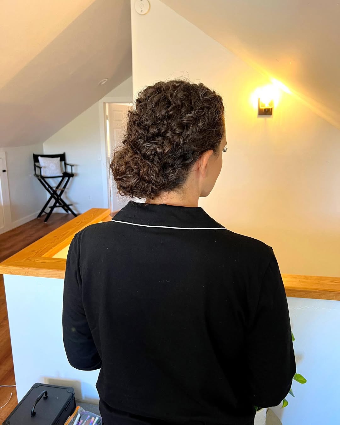 Close-up of a woman with long, voluminous, bouncy red curly hair, styled for summer. Her waves catch the light, perfect for summer hair curly ideas 2026.
