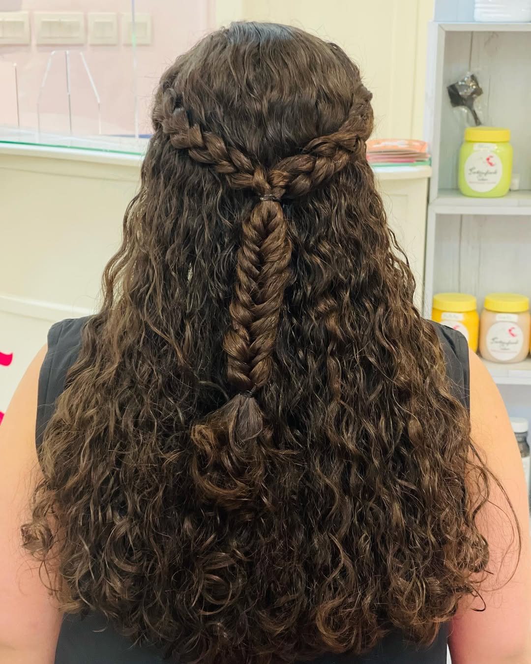 Close-up of a woman with vibrant, defined summer hair curly ideas 2026, showcasing healthy natural curls and sun-kissed highlights.