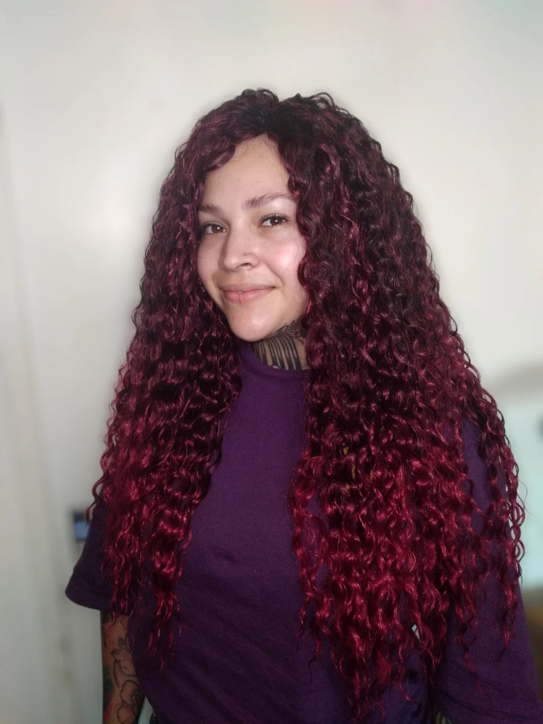 Woman with voluminous, defined summer hair curly ideas 2026, styled half-up with face-framing curls, perfect for a casual sunny day.