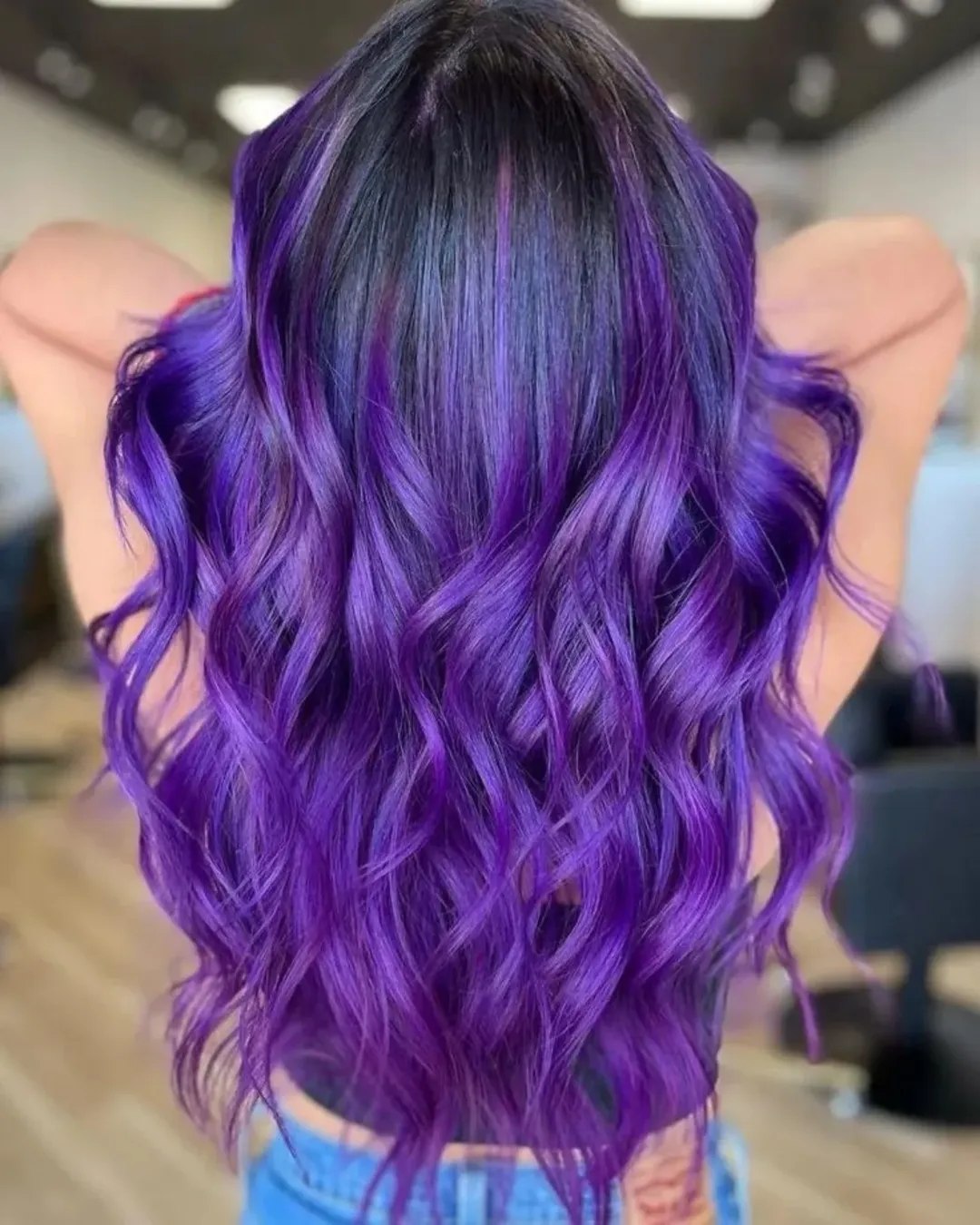 Close-up of a woman with vibrant pink and orange summer hair cute colors 2026, styled in soft waves with delicate face-framing pieces, exuding a playful and fresh aesthetic.