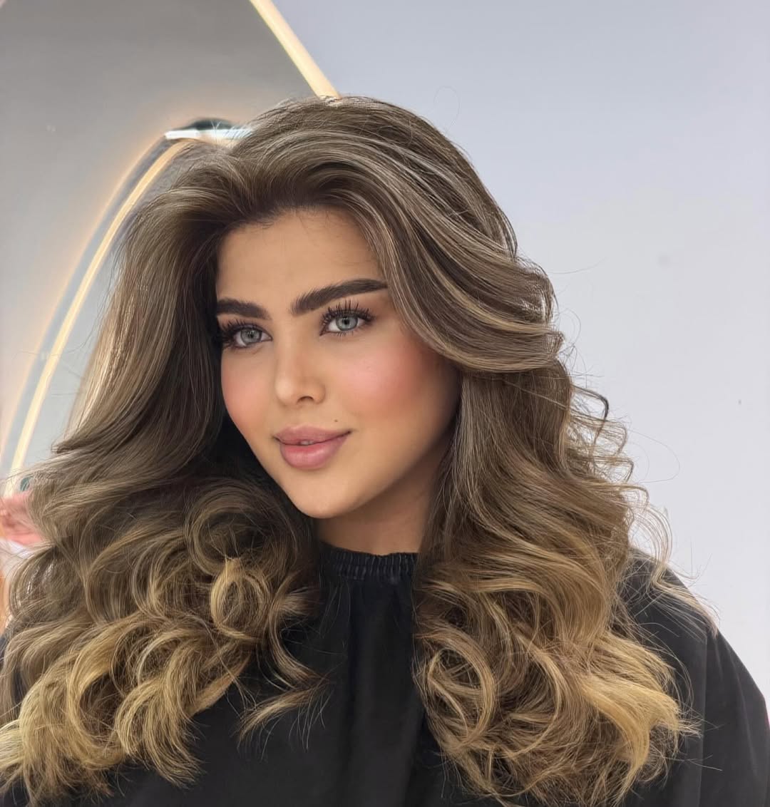Close-up of a woman with vibrant pink and purple ombre hair, styled in loose waves, showcasing summer hair cute colors 2026. Perfect for a fun, festival look.