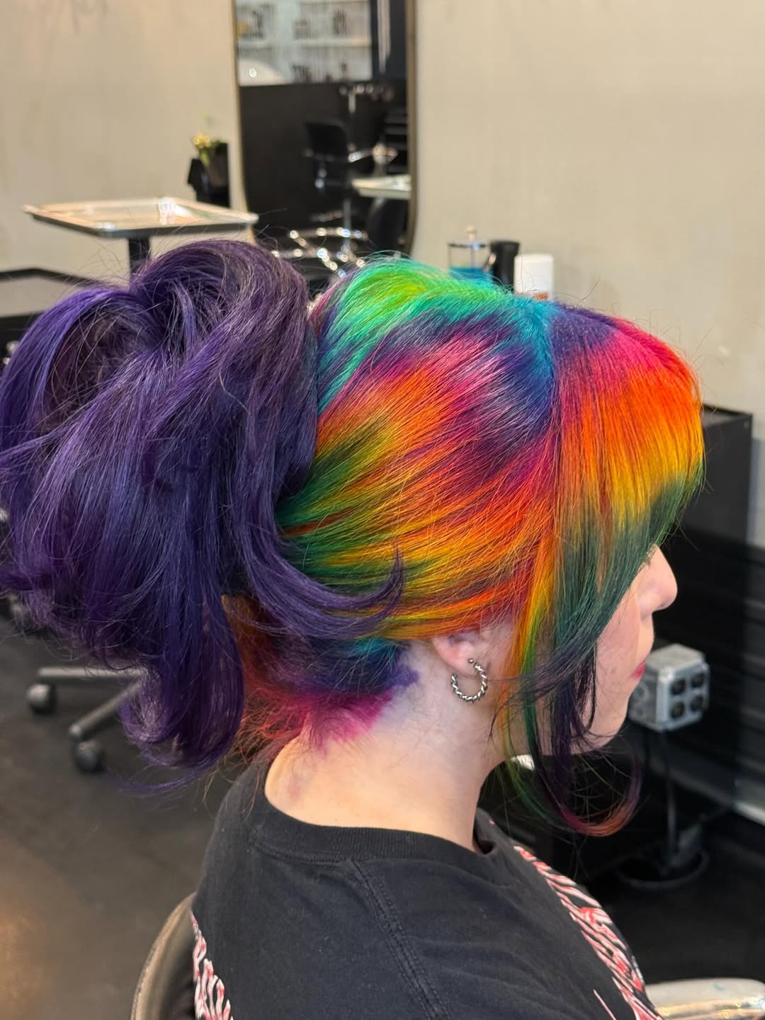 Close-up of a woman with vibrant pink and purple summer hair, cute colors for 2026, styled in soft waves. She wears a floral top, suitable for a casual day out.