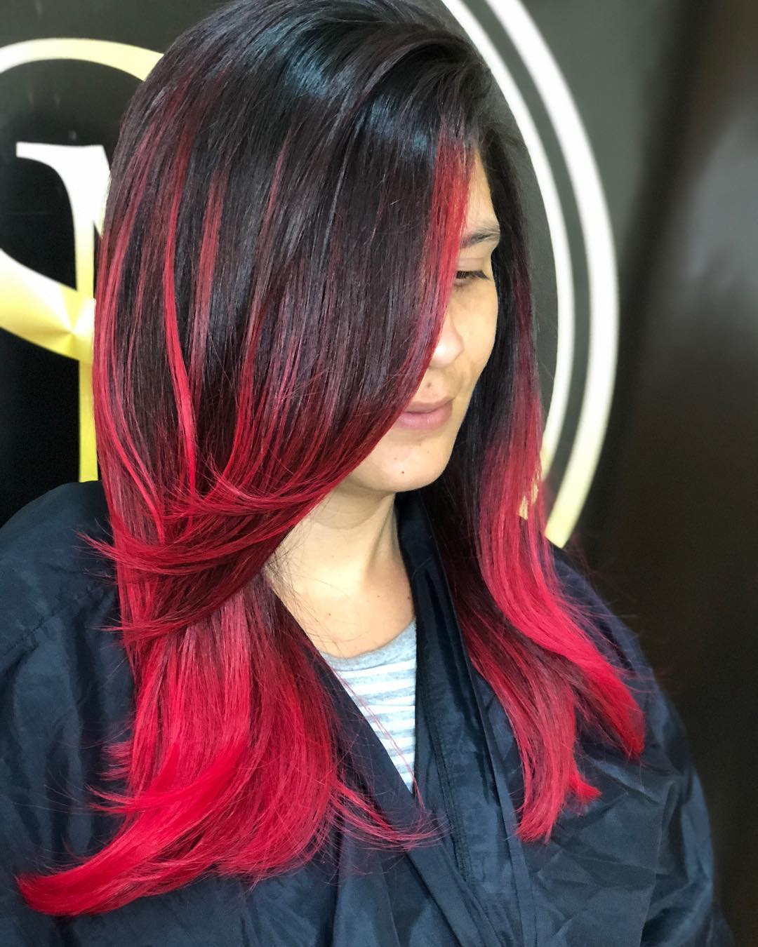 Close-up of a woman with vibrant pink and orange summer hair, styled in a cute wavy bob, perfect for 2026 trends.