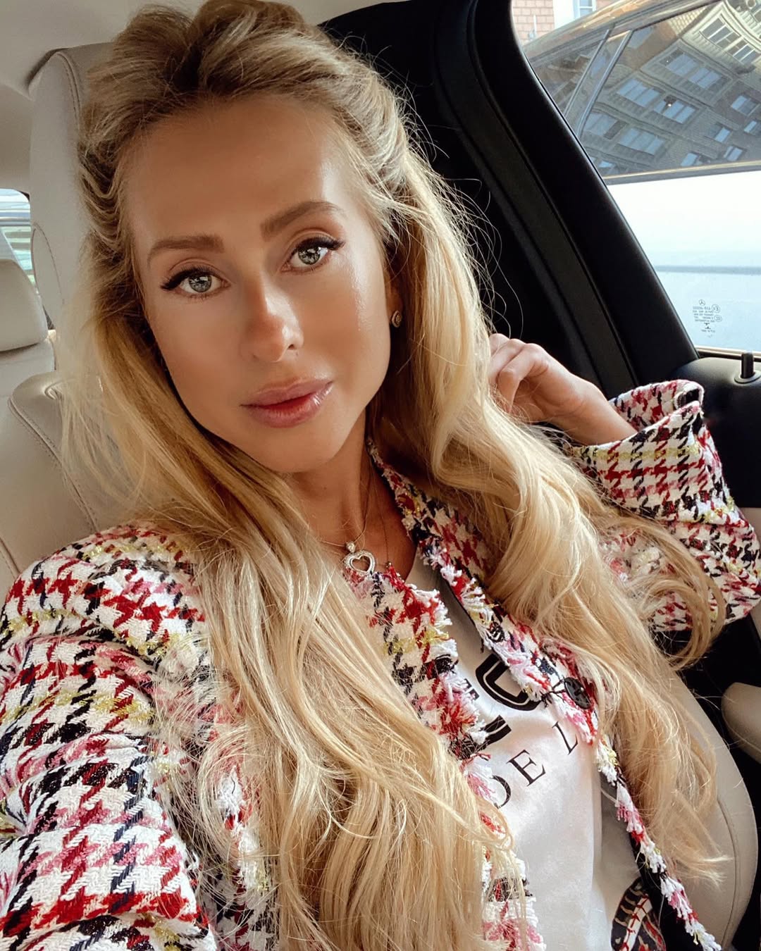 A woman confidently sports vibrant blue and pink ombré hair, a perfect example of summer hair cute colors 2026. Her long, wavy hair is styled in a half-updo, showcasing the bright hues.