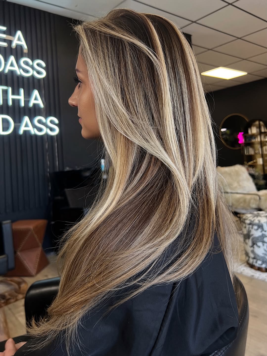 Woman with long, wavy blonde hair styled in beachy waves, perfect for showcasing summer hair trends 2026. Her hair is adorned with a delicate white floral headpiece, ideal for a garden party or outdoor event.