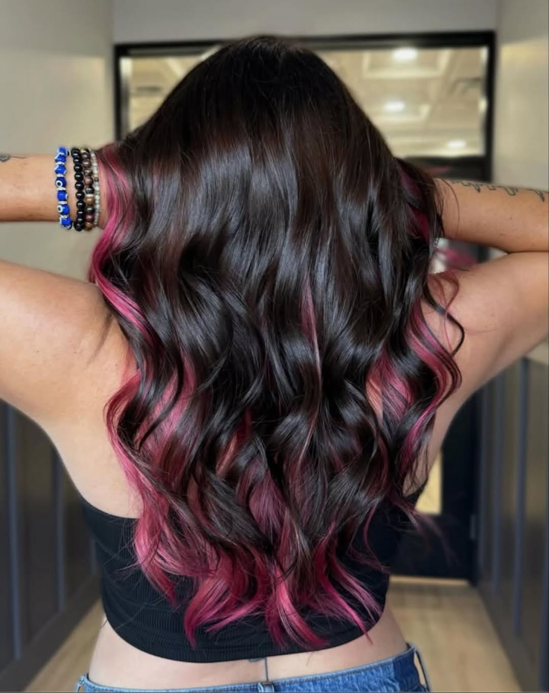 A woman confidently sports a sleek, high ponytail with face-framing tendrils, showcasing a chic summer hair trend for 2026. Perfect for active days or elegant evenings.