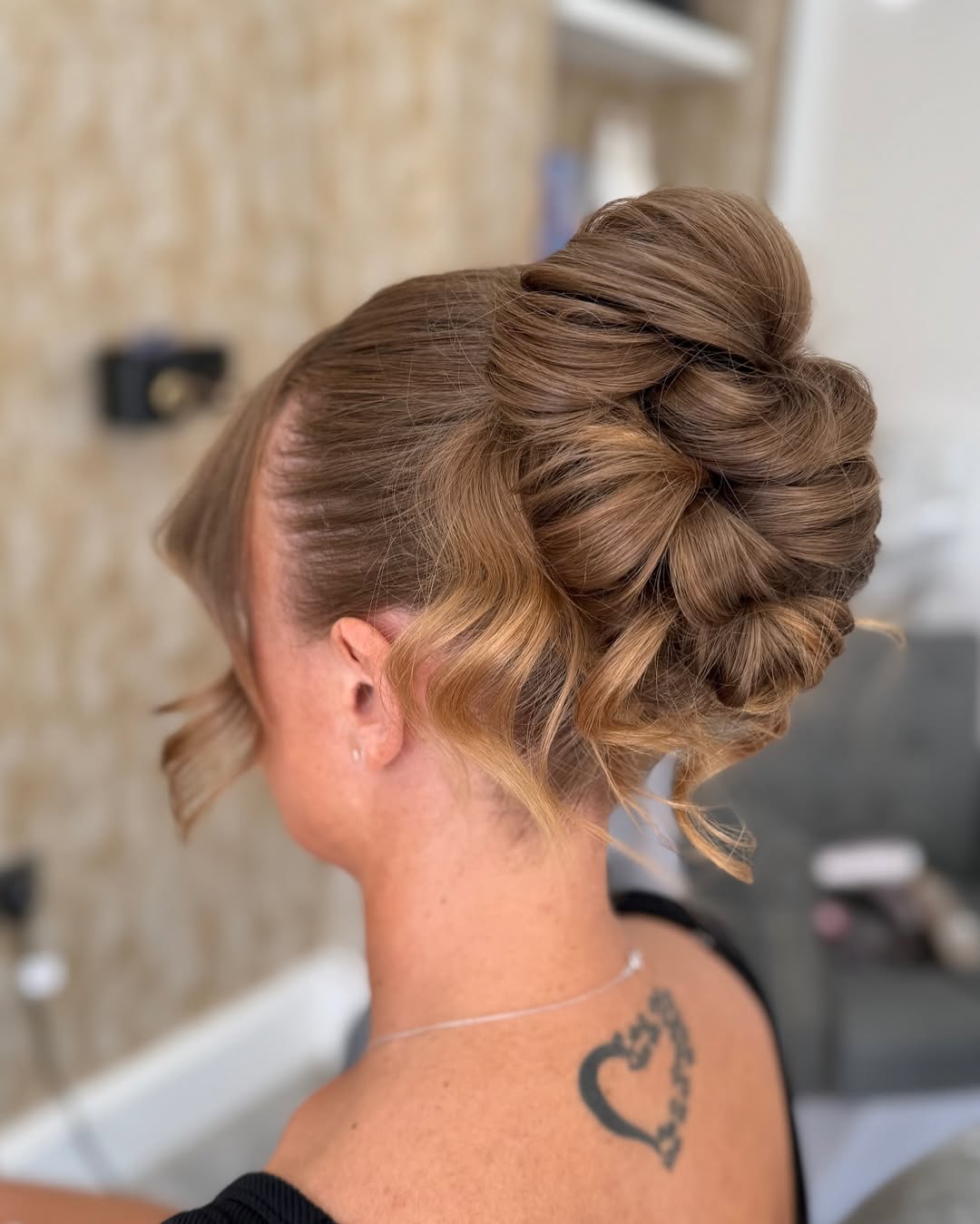 Beautiful blonde woman sporting a chic braided crown updo, perfect for summer hair updos, styled with loose tendrils framing her face, suitable for formal events or a romantic date night.