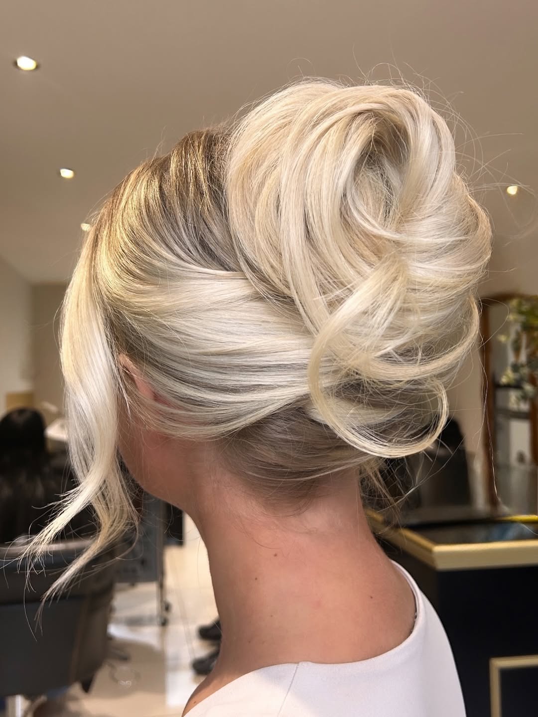 Woman with a beautiful braided updo, a perfect summer hair updo 2026. This intricate style features twists and braids, ideal for a chic outdoor event.