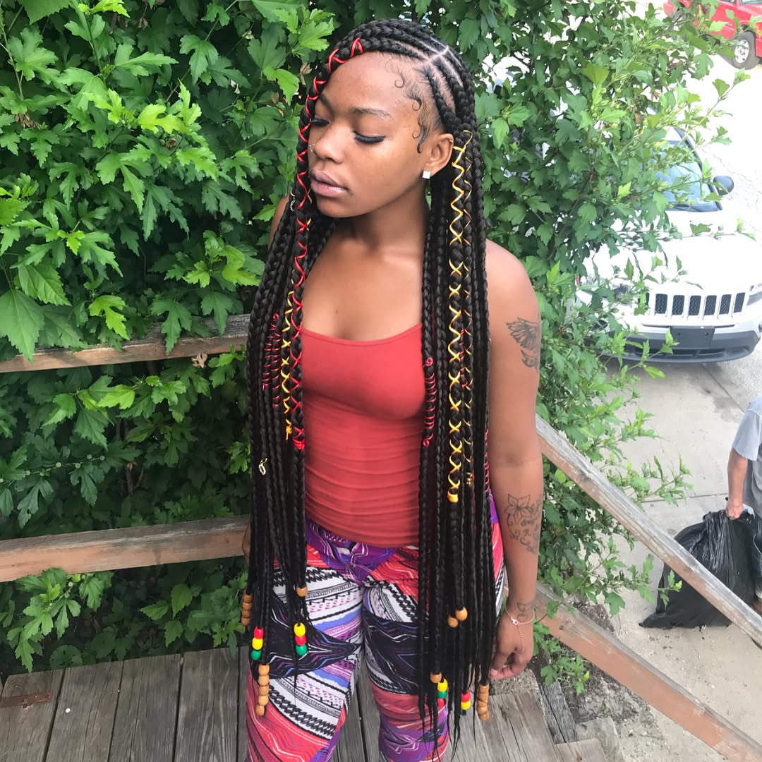 Close-up of a Black woman with a chic, high braided bun, perfect for stylish summer hairstyles black women 2026. Her hair is intricately styled, highlighting natural texture and elegance, suitable for sun-drenched days and evenings.