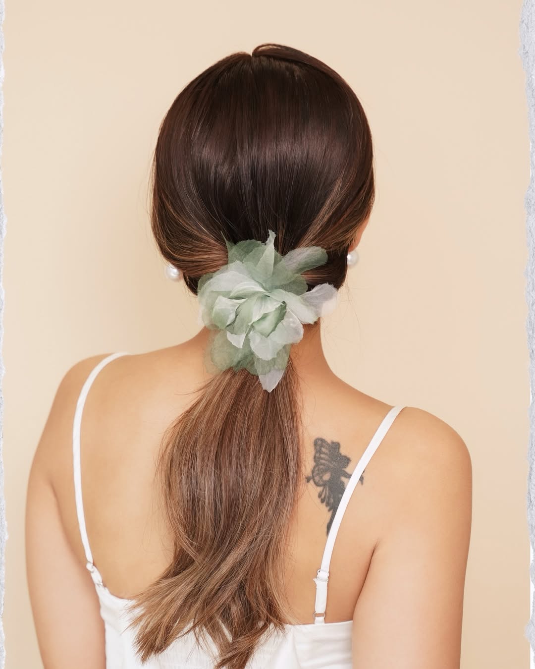 Woman with long brunette hair in a chic braided ponytail, perfect for summer hairstyles hot weather. Her hair is intricately braided along the crown, leading into a sleek, high ponytail, showcasing a stylish and practical updo for warm days.
